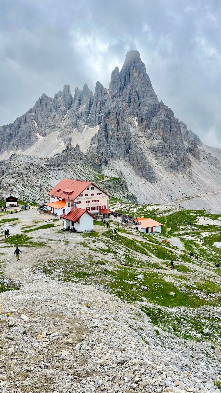 Dolomite mountain range with autumn trees and refuge