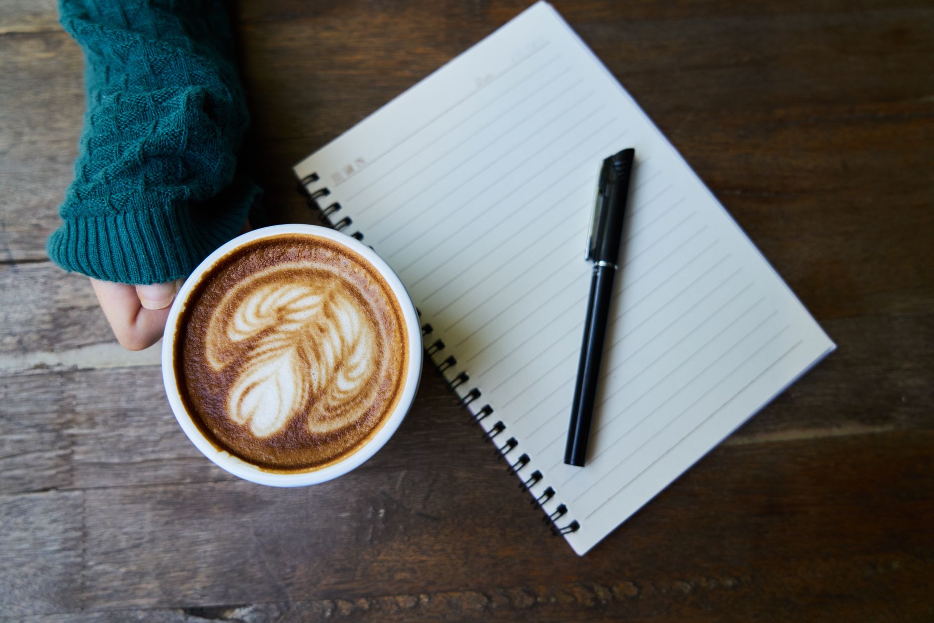 Coffee and notebook on rustic wooden table